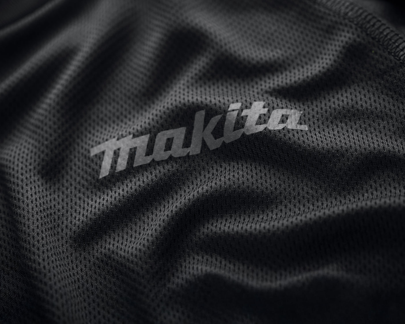 Close-up of Makita logo on a black Makita tech t shirt.