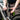 Image showing the Metabo GPS Tracker for iPhone being attached to the seat post of a silver / grey bicycle with cable ties to enable tracking of the bicycle. A person in brown trousers and a black top can be seen tightening the cable ties.