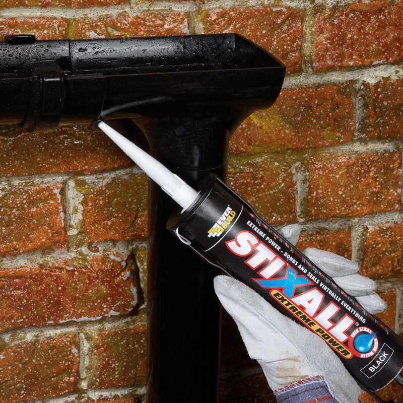 Person applying STIXALL Extreme Power sealant to a brick wall