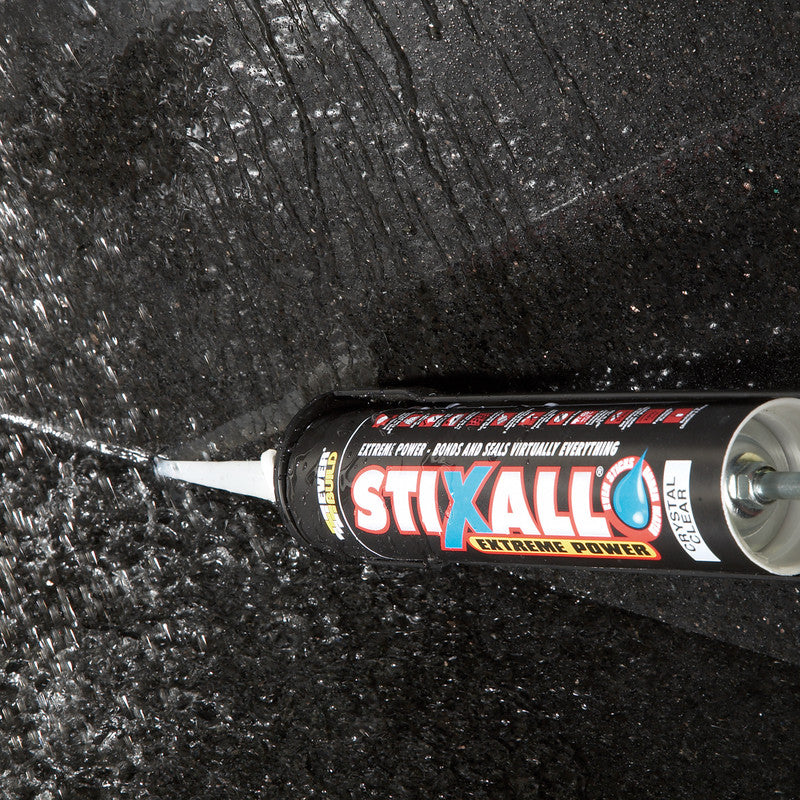 Stixall adhesive being used on a black textured surface.