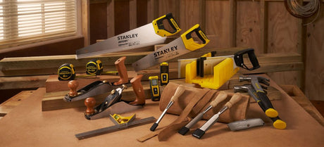 Collection of Stanley tools on a wooden surface with a workshop background
