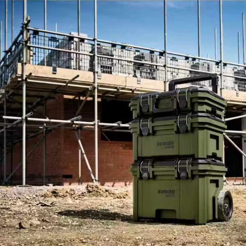 Stack of green storage boxes with wheels on a construction site
