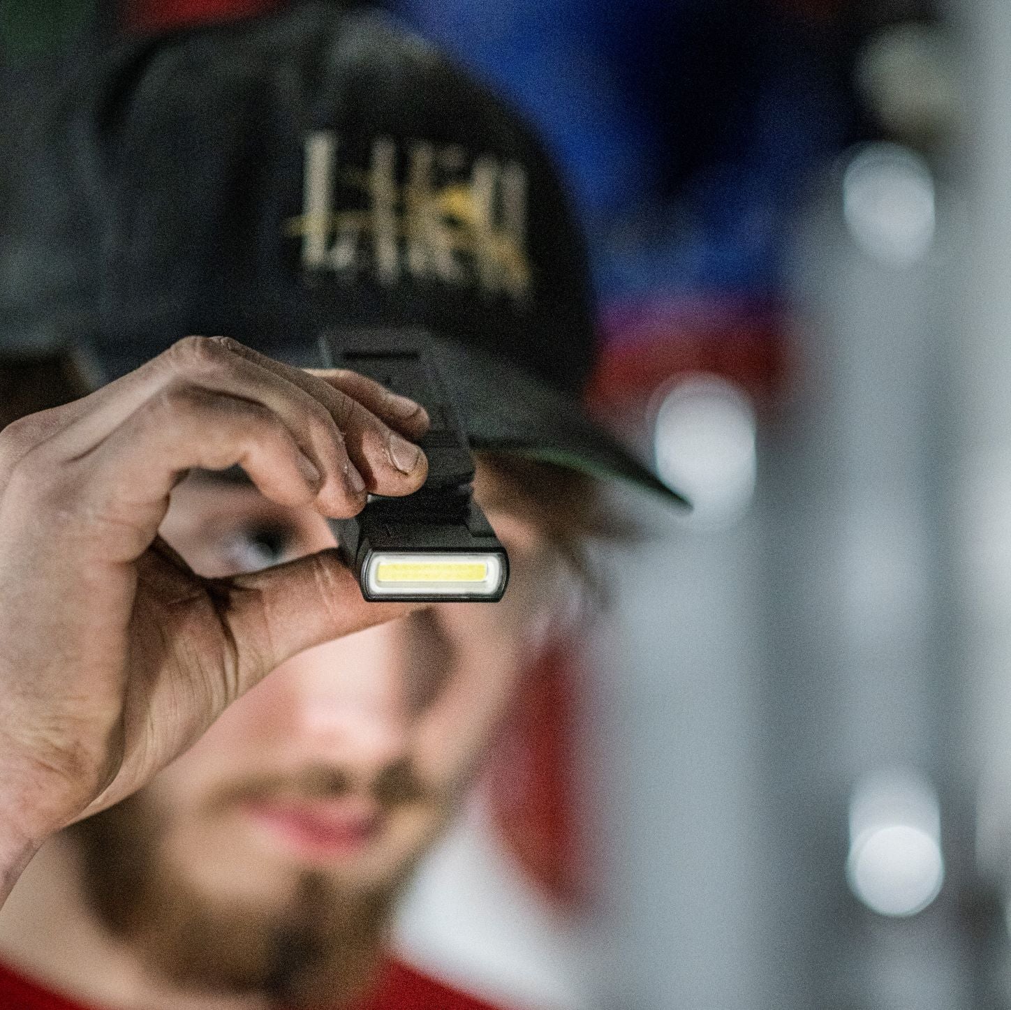 Person holding a Ledlenser W1R WORK Rechargeable ClipLight with a blurred background