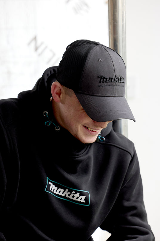 Person wearing a Makita origin trucker cap and hoodie.