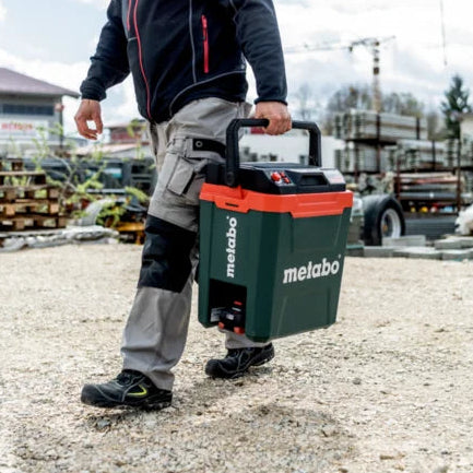 Person carrying a Metabo coolbox on a construction site