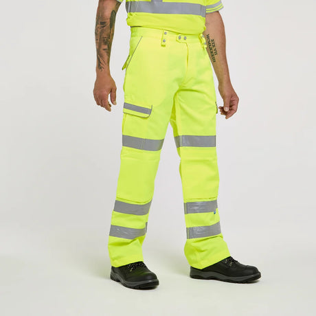 Person wearing high-visibility yellow work pants with reflective stripes on a white background