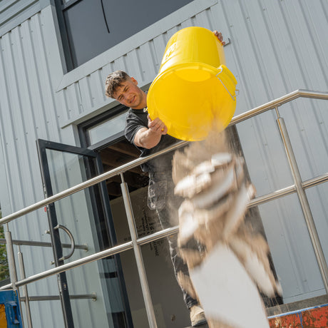 Gorilla Bin™ 30L Mixing Bucket - Yellow RG30.Y shown being used to tip material to a skip