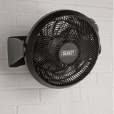 Black Sealey wall-mounted fan on a white brick wall
