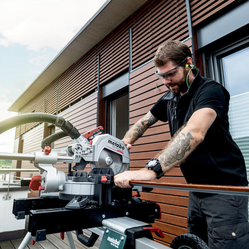 Metabo KGS 18 LTX BL 216 crosscut mitre saw 614216850 shown cutting composite panelling, close up.
