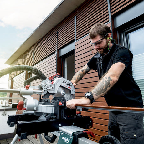 Metabo KGS 18 LTX BL 216 crosscut mitre saw 614216850 shown cutting composite panelling, close up.
