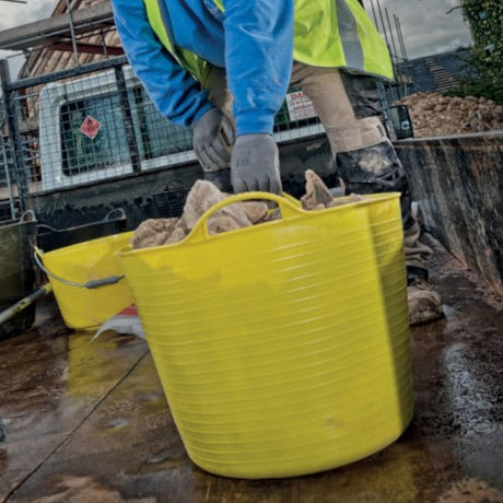 Red Gorilla flexible tub 14L in yellow holding heavy bricks.