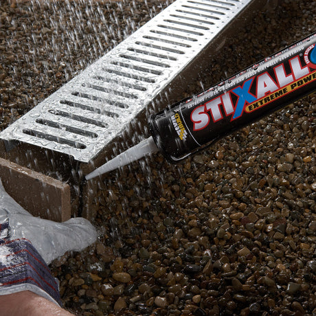 Person applying STIXALL extreme power sealant to a drain cover.
